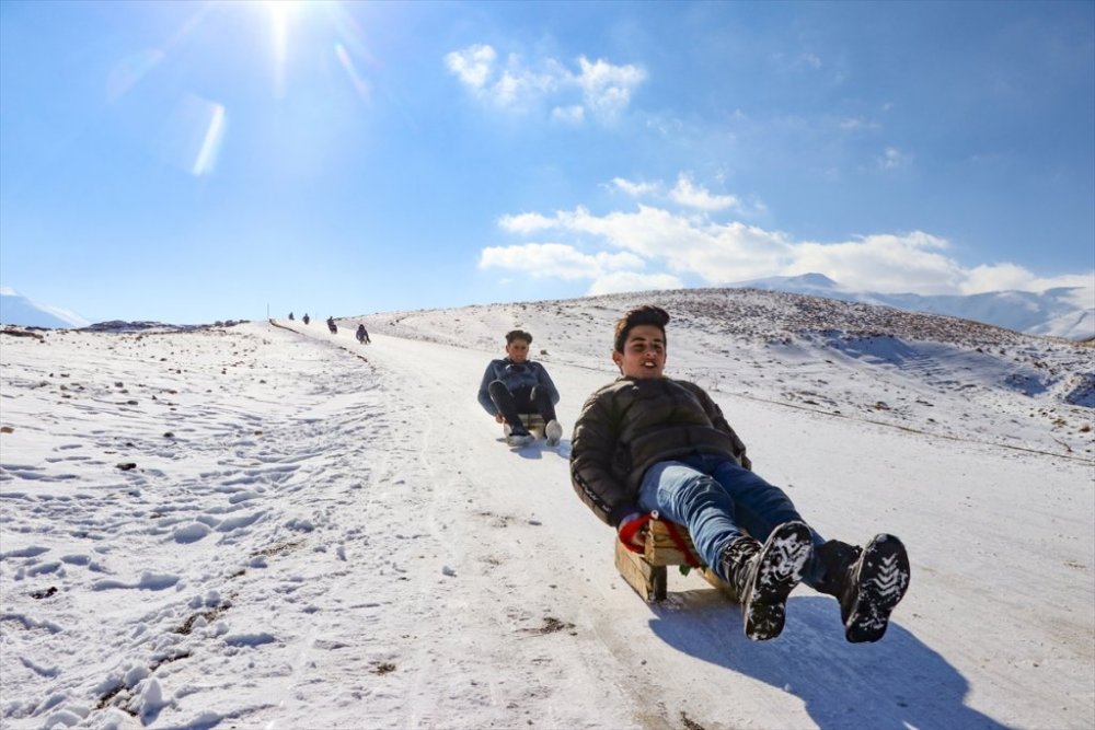 Çocuklar karlı tepeleri kayak pistine dönüştürdü