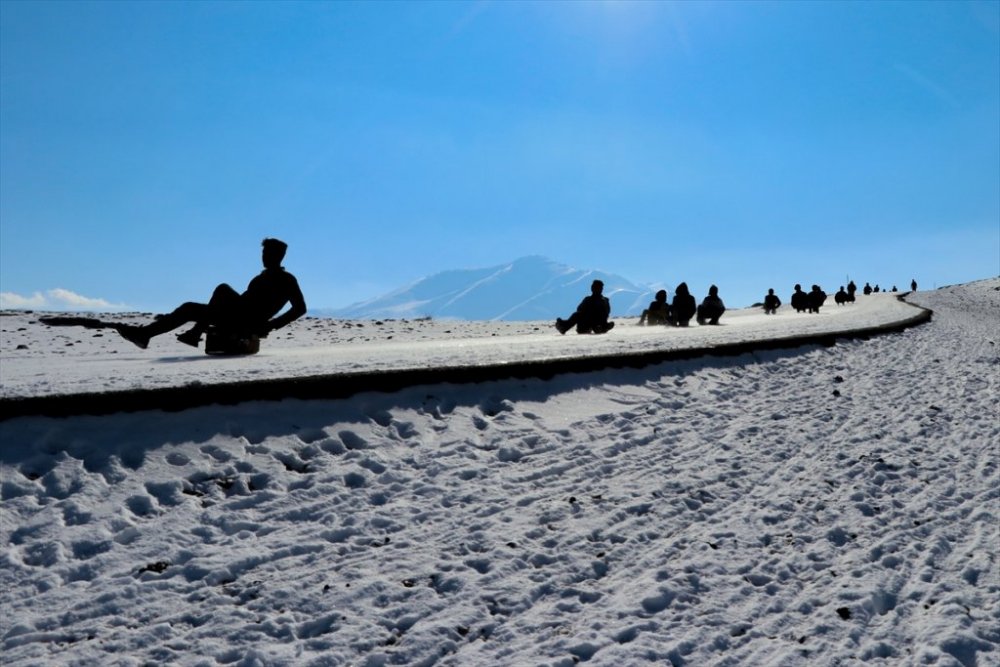 Çocuklar karlı tepeleri kayak pistine dönüştürdü